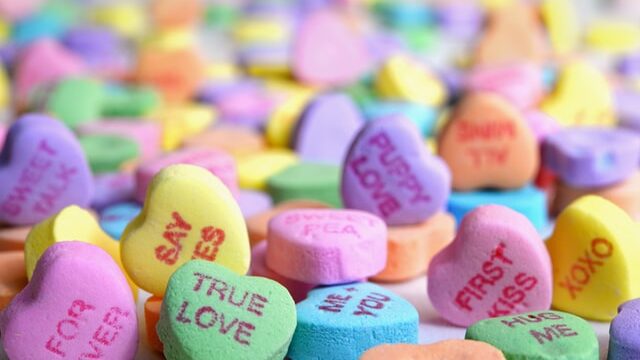 En la imagen se ve dulces en forma de corazón y con frases romanticas.